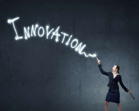 Businesswoman in darkness drawing word promotion with flashlightの写真素材