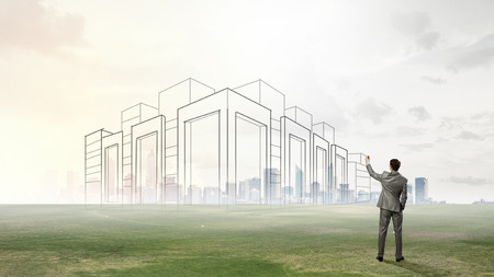 Young man engineer drawing urban construction projectの写真素材