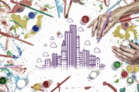 Top view of hands drawing buildings creative concept with paintsの写真素材