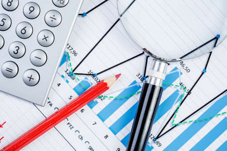 Image of businessman workplace with papers and magnifying glass