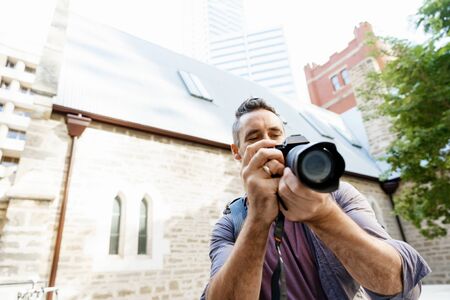 Professional photographer taking picture in cityの写真素材