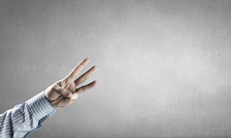 Hand of businessman showing three gesture with fingers