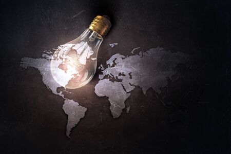 Glass glowing light bulb on stone backgroundの写真素材