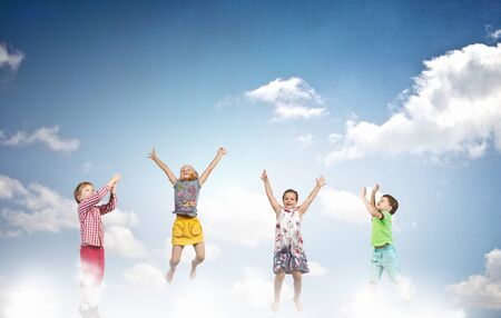Group of children jumping high in sky joyfullyの写真素材