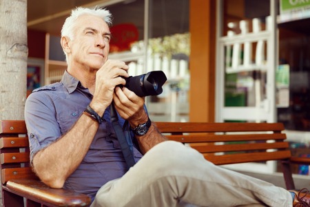 Senior man with camera in city