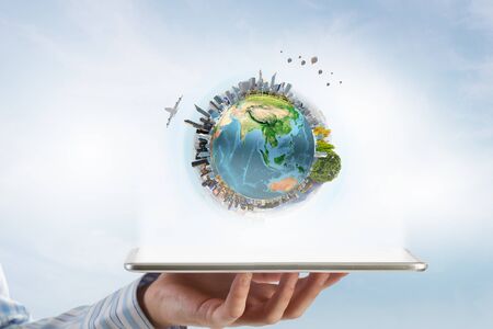 Businessman hands holding tablet pc with Earth planet on it.