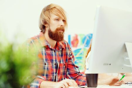 Handsome businessman in casual wear working in office