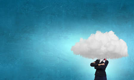 Businesswoman in suit standing with her head in cloud