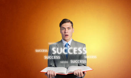 Young businessman holding in hands blank opened bookの写真素材