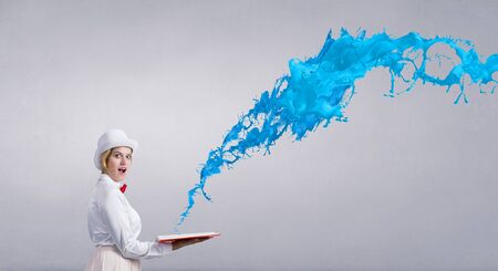 Young woman in white hat with opened book in hands and splashes flying out