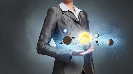 Close up of businesswoman holding planets of sun system in handの写真素材