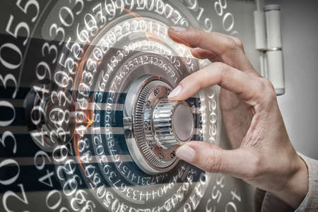 Young businesswoman enter code to open safeの写真素材