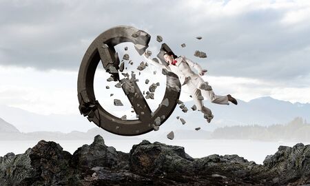 Young emotional woman crashing prohibition stone signの写真素材