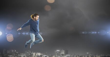 Young dancer man in jump over dark backgroundの写真素材