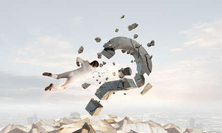 Emotional businesswoman destroying with arm stone question markの写真素材