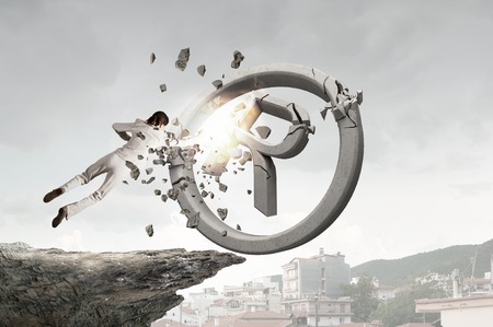 Determined businesswoman breaking stone copyrighting sign with hand punchの写真素材