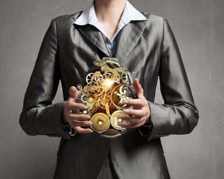 Close up image of businesswoman holding gears mechanism in handsの写真素材