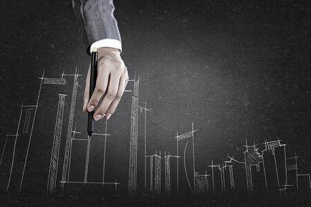 Close up of hand drawing construction project on black wallの写真素材