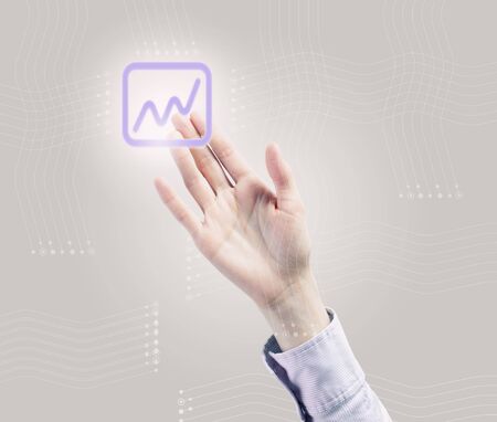 Male hand touching with finger growing graph iconの写真素材