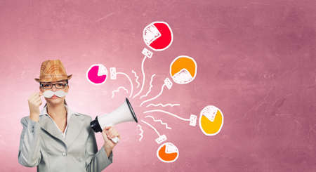Attractive businesswoman with paper mustache and megaphone in handの写真素材