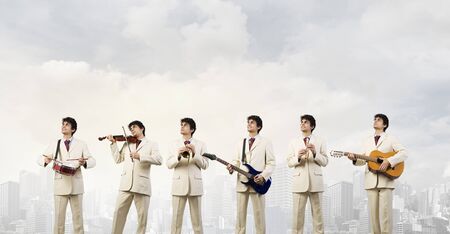 Man orchestra in suit playing different music instruments