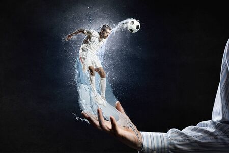 Soccer player with ball in action in male palmの写真素材