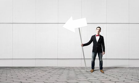 Young man in jacket and bowtie holding signの写真素材