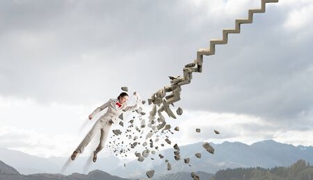 Young businesswoman crashing stone staircase representing success conceptの写真素材