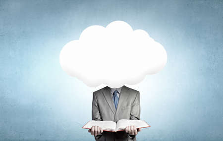 Young businessman with book in hands and cloud instead of headの写真素材