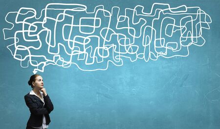 Thoughtful businesswoman and drawn arrow thoughts out of her headの写真素材