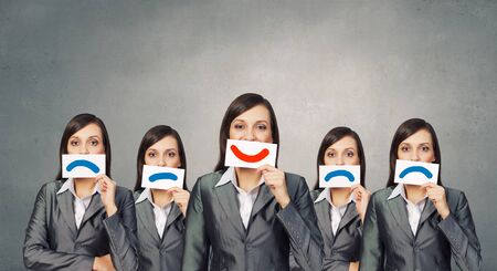 Pretty young girl holding white card with drawn smileの写真素材