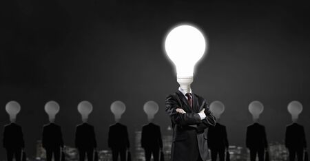 Businessman with light electric bulb instead of head as symbol of bright ideaの写真素材