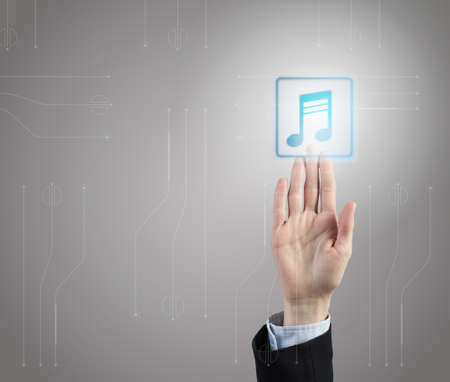 Male hand pressing music icon on media interfaceの写真素材