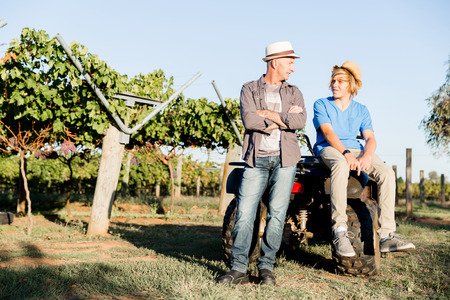 Father and son standing next to car in vineyardの写真素材
