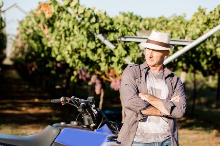 Man wearing hat standing in vineyard
