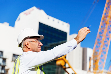 Engineer builder wearing safety vest at construction siteの写真素材