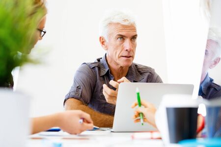 Handsome businessman in casual wear working in officeの写真素材