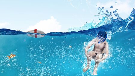 Kid boy of school age in diving mask jumping in waterの写真素材