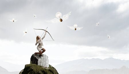 Young woman archer in suit aiming to idea bulb