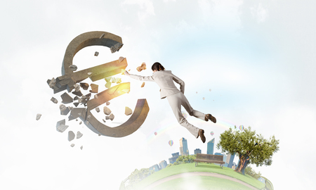 Emotional businesswoman breaking with hand stone euro symbolの写真素材
