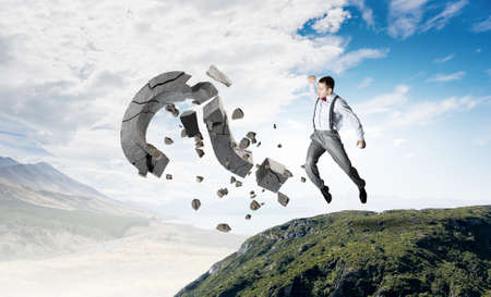 Emotional businessman destroying with arm stone question markの写真素材