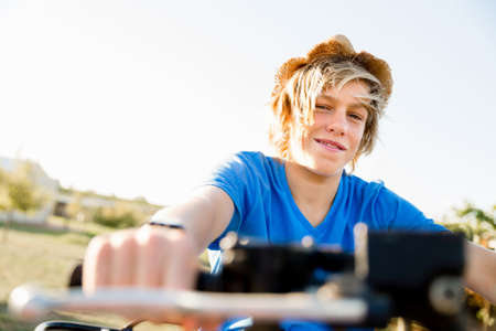 Boy wearing hat and riding farm truck in vineyardの写真素材
