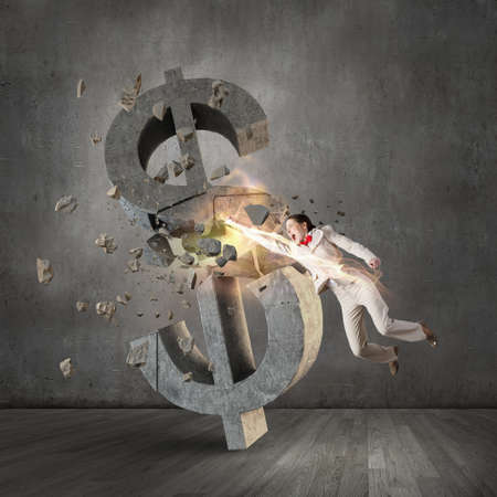 Emotional businesswoman breaking with hand stone dollar symbolの写真素材