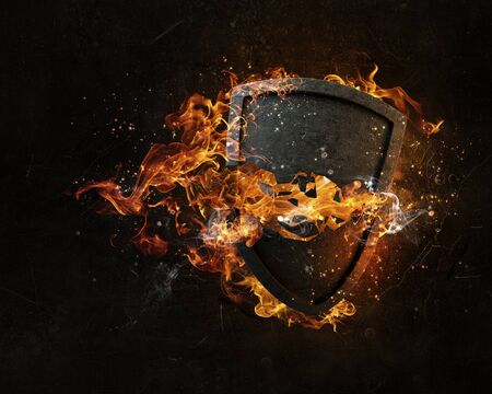 Stone broken shield in fire flames on dark backgroundの写真素材