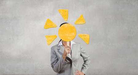 Businesswoman in suit hiding her face behind maskの写真素材