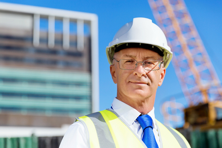 Engineer builder wearing safety vest with notepad at construction siteの写真素材