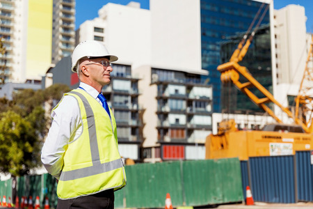 Engineer builder wearing safety vest at construction site