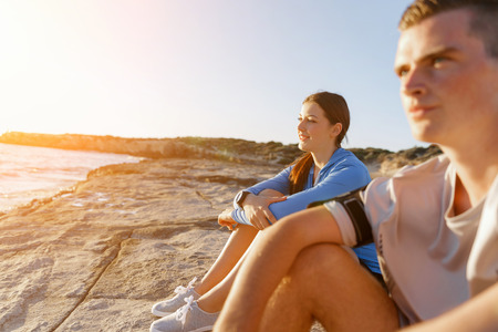 Young coulpe in sport wear sitting on beachの写真素材