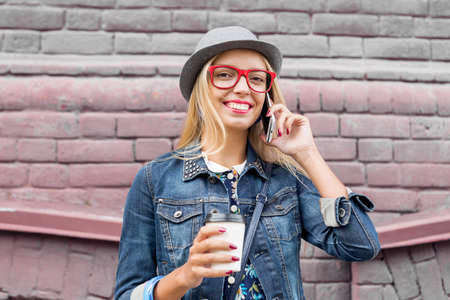 Young pretty girl tourist walking the street and talking on mobile phoneの写真素材