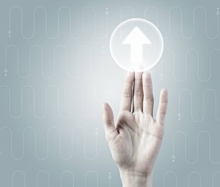 Hand touching arrow media icon on virtual interfaceの写真素材